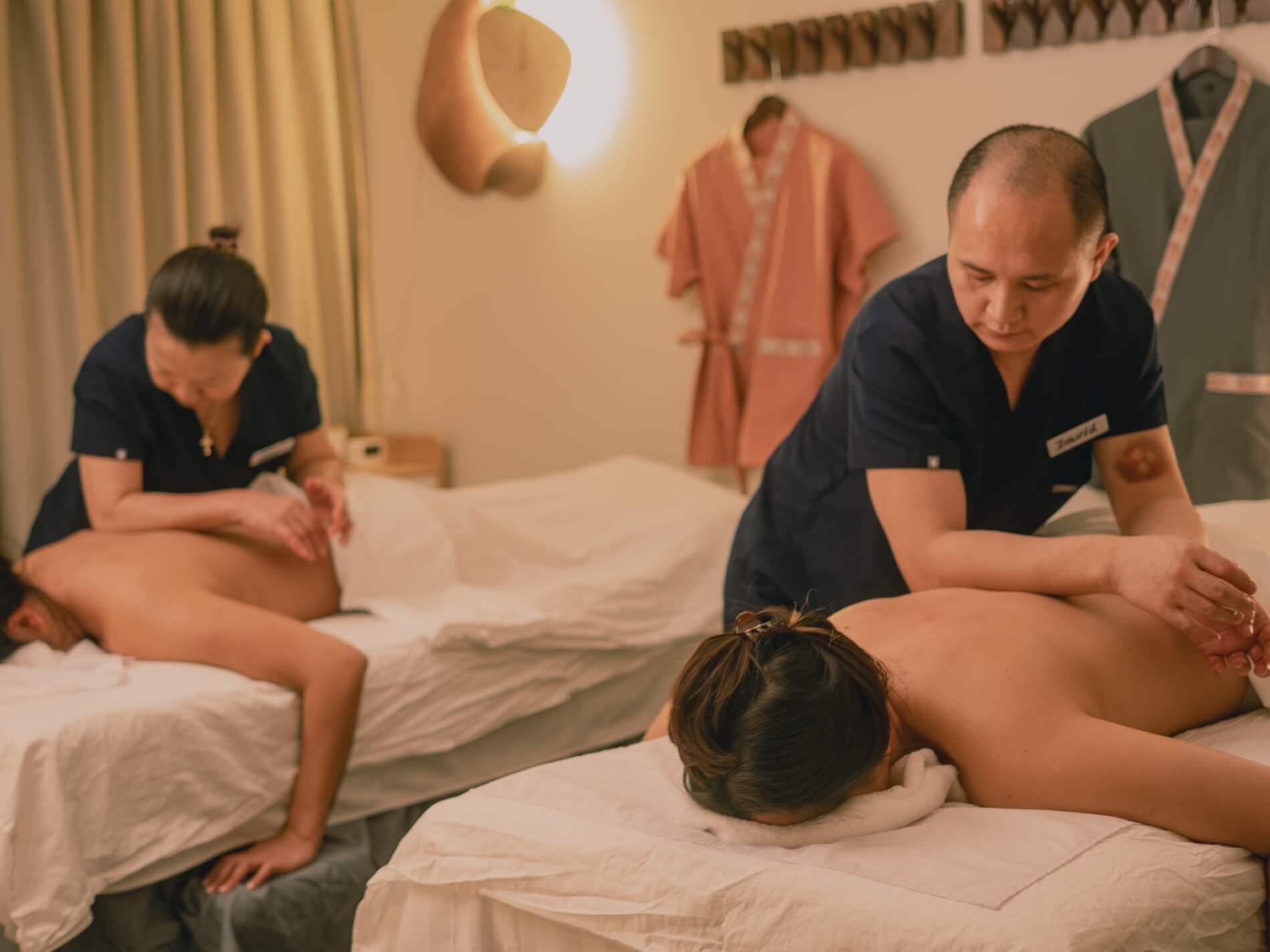 Two therapists treating two clients side by side in one room